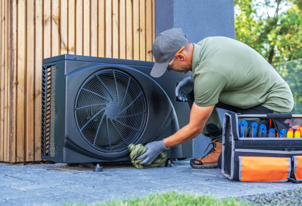 handsome young man electrician installing an air conditioning in a client house