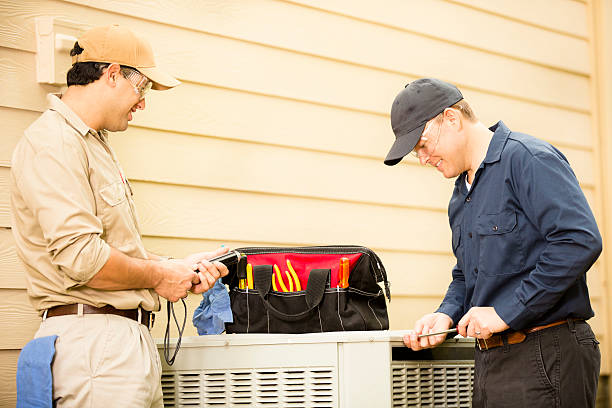 Two men performing HVAC repair in Lauderdale Lakes FL using tools and equipment, focused on fixing an air conditioning unit.