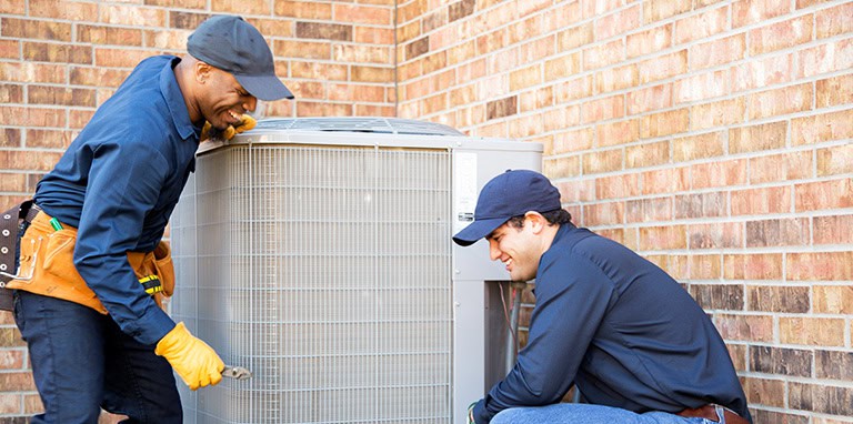 Technician performing maintenance on HVAC unit outdoors