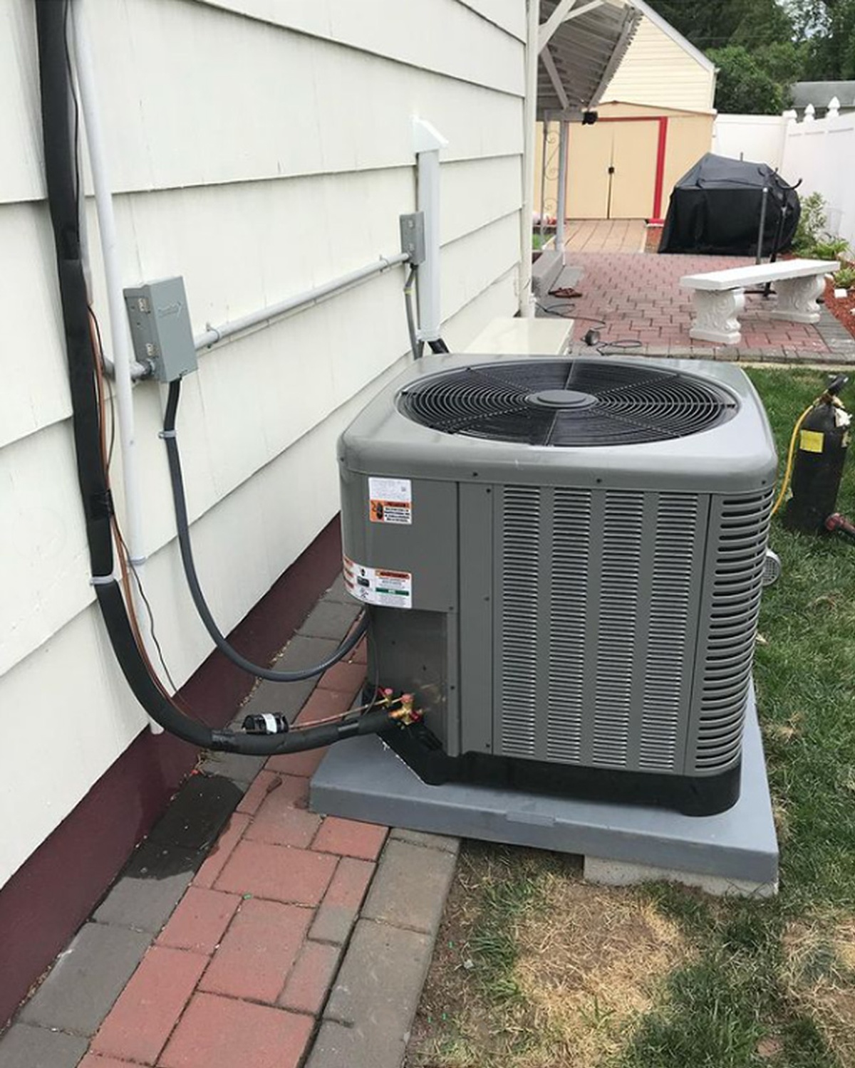 Technician inspecting AC unit air vents outdoors