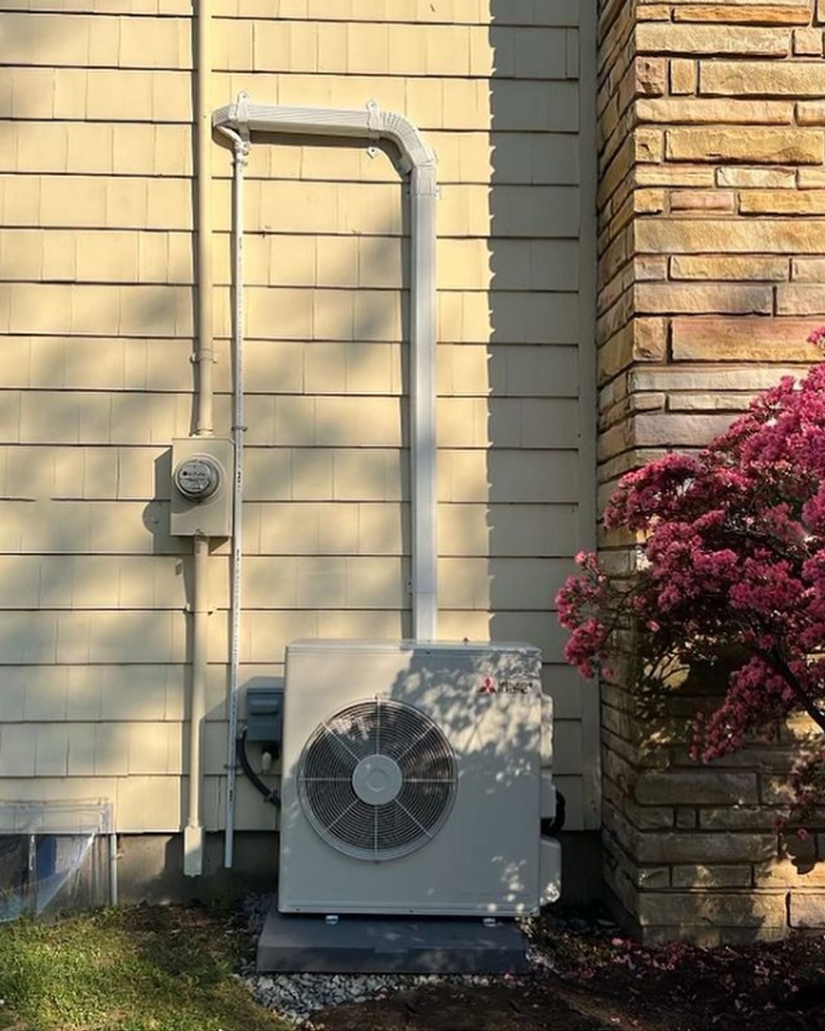 Technician servicing outdoor split AC unit on wall