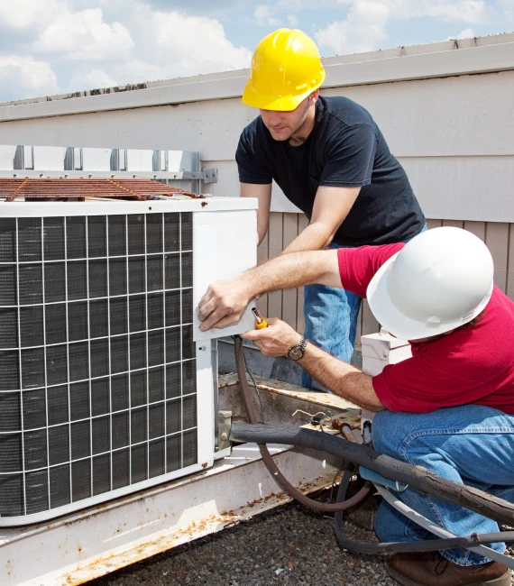 Air conditioner unit technician lifting outdoor condenser