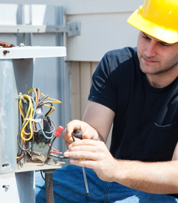 Air conditioning technician lifting outdoor condenser unit for installation