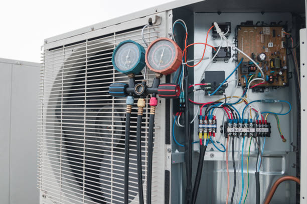 A technician works on an air conditioning unit as part of an HVAC tune-up service.