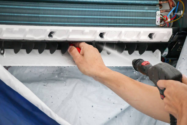 A person using a power tool to clean a window, demonstrating effective maintenance techniques for home improvement.