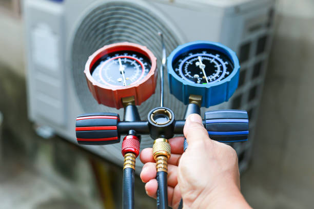  Two technicians in blue shirts work on an air conditioner during an emergency repair.